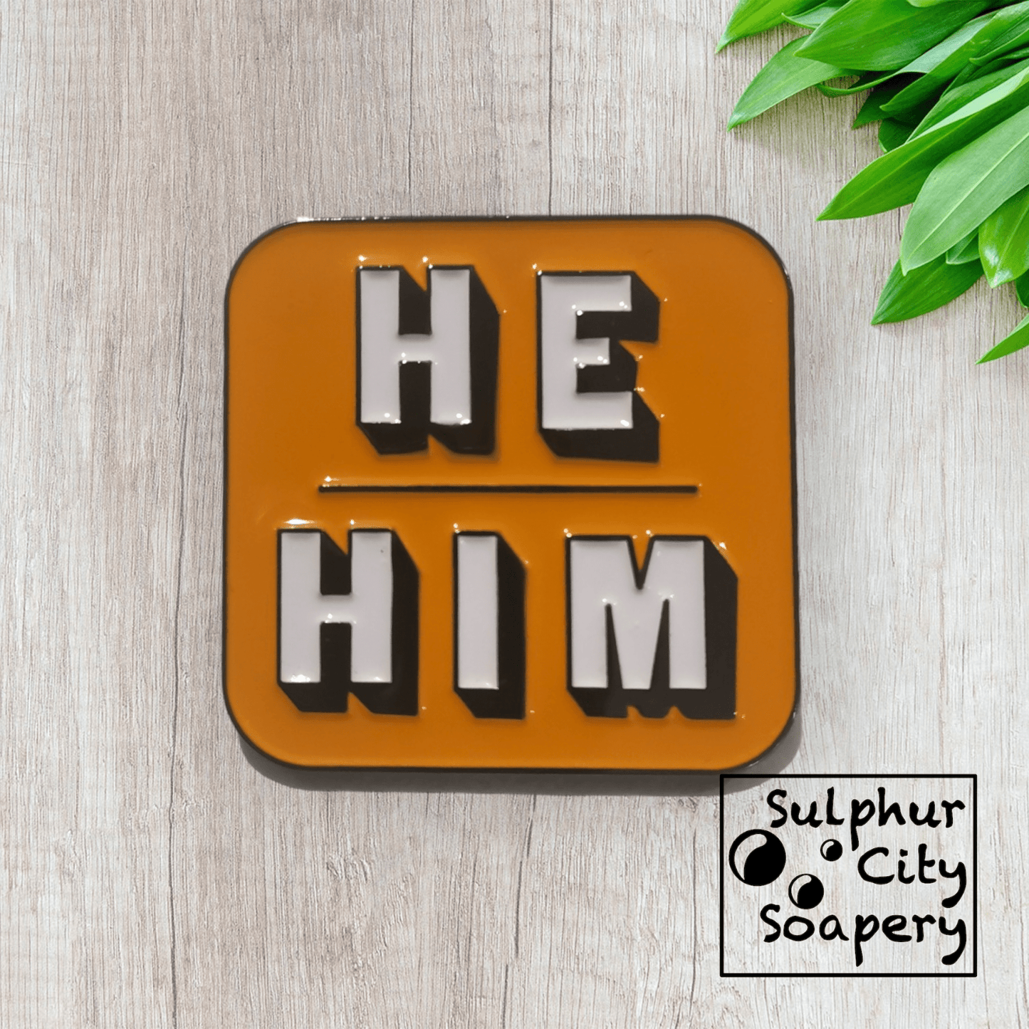 Sulphur City Soapery pronoun pin Pronoun pin in black and orange -  He / Him